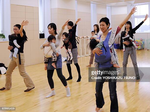 Young mothers, holding their babies with baby-slings, train in samba dances, called "baby-dance", at a studio in Yokohama city, suburban Tokyo on...