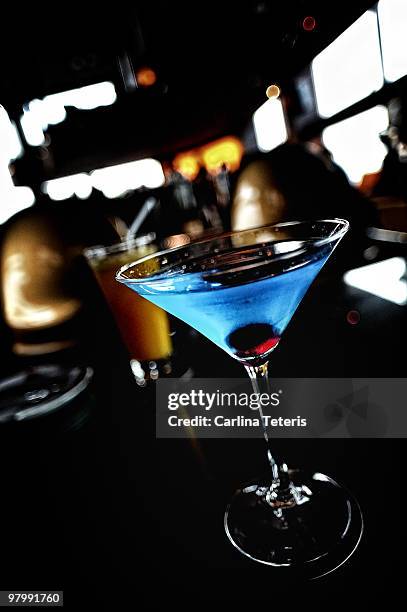 blue drink in a martini glass - blue martini glasses stock-fotos und bilder