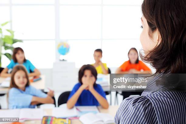 elementary pupils on a lesson listening to teacher. - secondary colors stock pictures, royalty-free photos & images