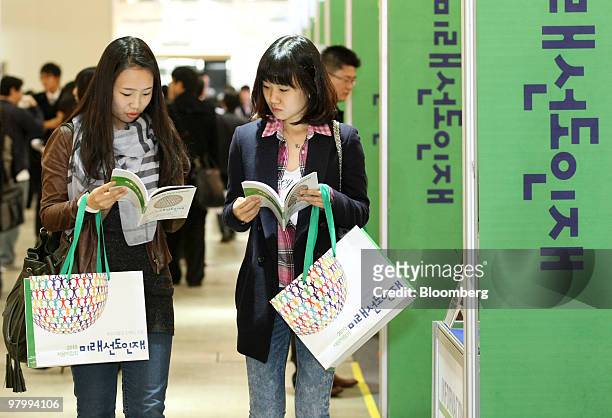 University students Eun-Hye Kwak left, and Yeon-Ji Kim look at employment information booklets at a job fair organized by the Ministry of Knowledge...