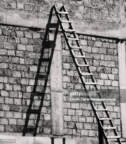 ladder leaning against brick wall - ladder leaning stock pictures, royalty-free photos & images