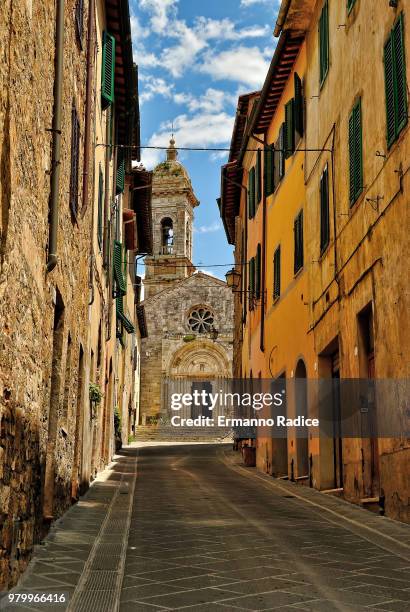 narrow street and church of old town san quirico dorcia, san quirico dorcia, tuscany, italy - radice stock-fotos und bilder