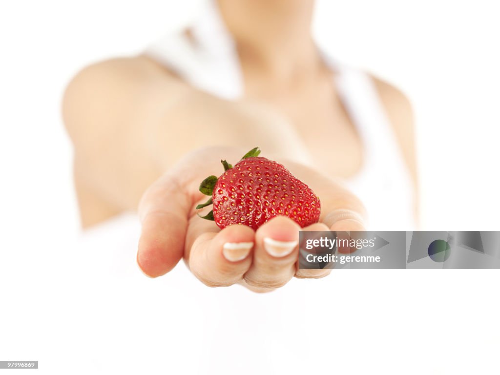 Woman holding fresh strawberry