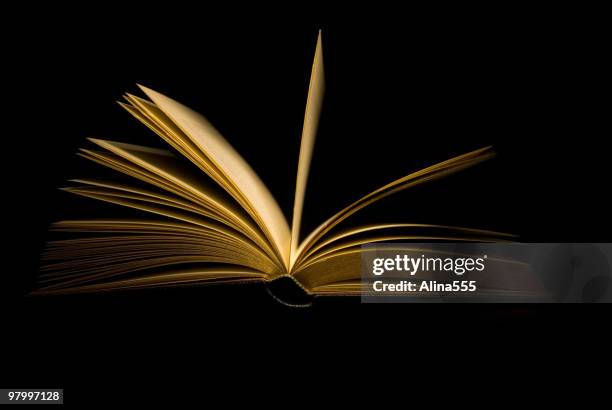 open book on black background - mystery book stock pictures, royalty-free photos & images