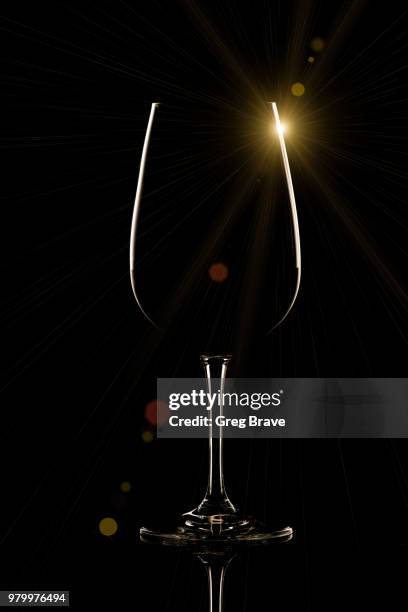 wine glass on black background with sun flare - sun flare on glass stockfoto's en -beelden