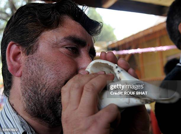 Kashmiri Hindu blows a conch shell during Navratra-prayer rituals at Ram Temple in Srinagar on March 24,2010. Hindus constitute a religious minority...