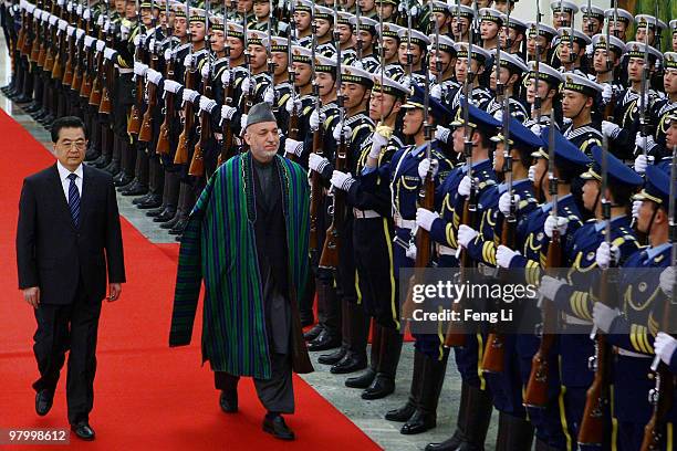 Chinese President Hu Jintao accompanies Afghan President Hamid Karzai to view an honour guard during a welcoming ceremony inside the Great Hall of...