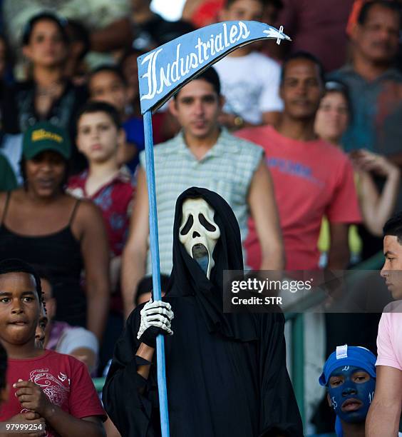 Fan of Cuban baseball team Industriales cheers his team at the Latinoamericano stadium in Havana, on March 14, 2010 during the 49th National Baseball...