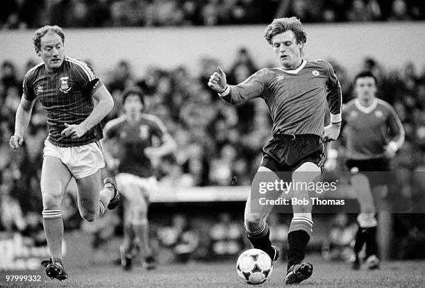 Gordon McQueen of Manchester United with the ball watched by Ipswich Town striker Alan Brazil during the Division One League match against Ipswich...