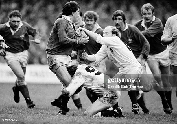 Welsh lock Robert Norster is tackled by England's Steve Smith and Les Cusworth during the Rugby Union International match held at Cardiff Arms Park...