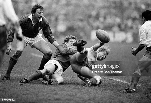 Ireland flanker Fergus Slattery tackles France captain Jean Pierre Rives as Ireland's Willie Duggan looks on during the Rugby Union International...