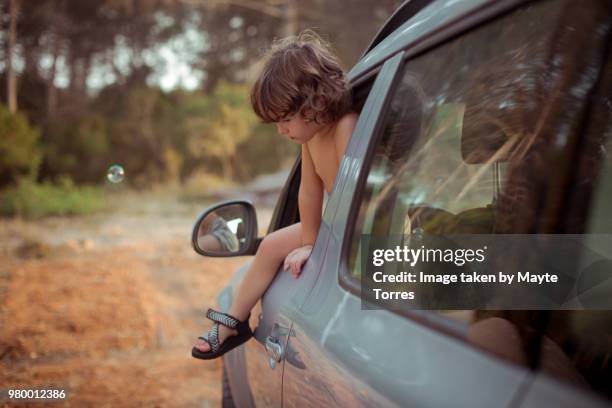 boy trying to get out of the car through the window - vista dalla parte posteriore di un veicolo foto e immagini stock