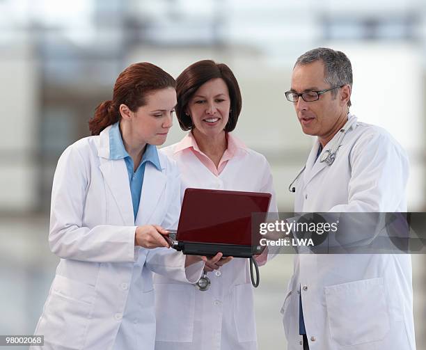 doctors having a meeting, using netbook - netbook stock-fotos und bilder