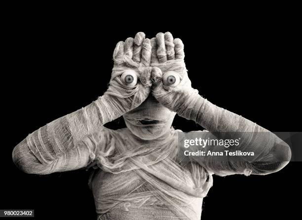 man wearing mummy costume with eyeballs on hands - mummified stock pictures, royalty-free photos & images