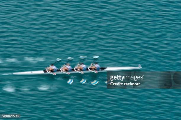quadruplo scull rowing team pratica, movimento sfocato - sport di squadra foto e immagini stock