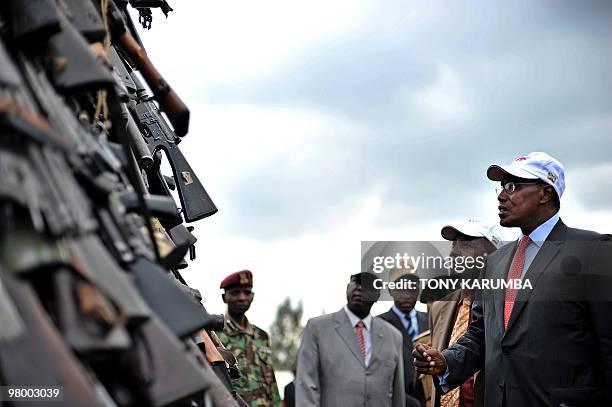 Kenyan government minister George Saitoti inspects a cache of illegal fire arms in Nairobi, March 24, 2010 before it is set abalaze as part of a...