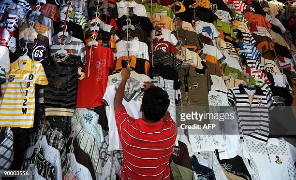 Sri Lankan vendor sells t-shirts from a stall on a street in Colombo on March 18, 2010. AFP PHOTO/Ishara S.KODIKARA