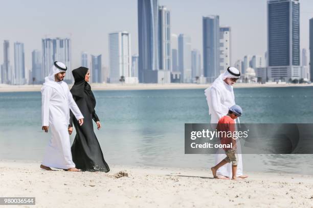 famiglia araba che cammina sulla spiaggia autunnale - kuwait foto e immagini stock