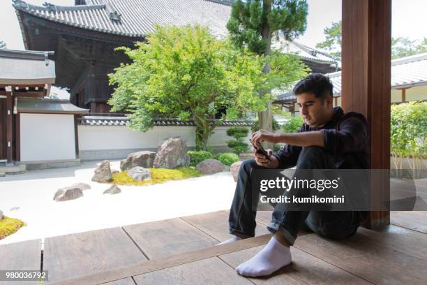 gemischte raste mann sitzt im tempel - indischer subkontinent abstammung stock-fotos und bilder