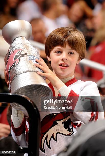 Young male Phoenix Coyotes fan holds up a home made replica of the Stanley Cup during a game against the Chicago Blackhawks on March 20, 2010 at...