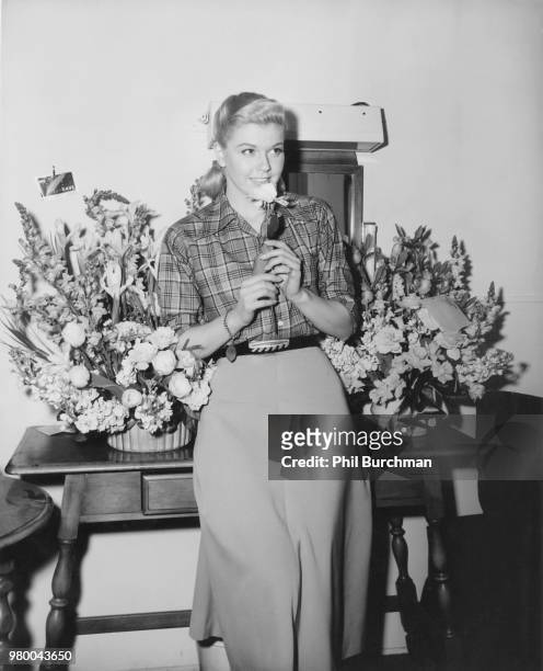 American actress and singer Doris Day with flowers from admirers, on the set of the musical romantic comedy, 'My Dream Is Yours', directed by Michael...