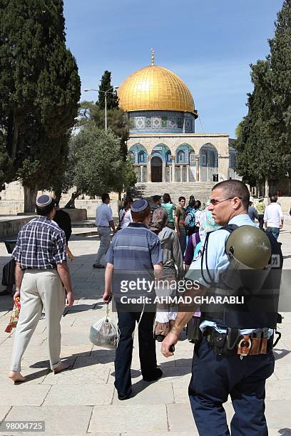 Jewish tourists walk in front of the Dome of the Rock as they visit the Al-Aqsa mosques compund under Israeli police protection in Jerusalem's Old...