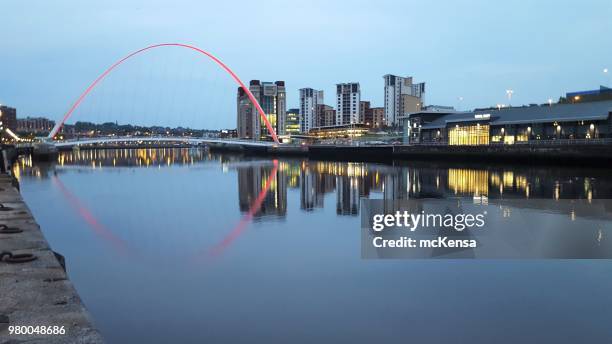 puente del milenio sobre el río tyne a newcastle y gateshead, con el centro báltico de arte contemporáneo en fondo - puente del milenio de gateshead fotografías e imágenes de stock