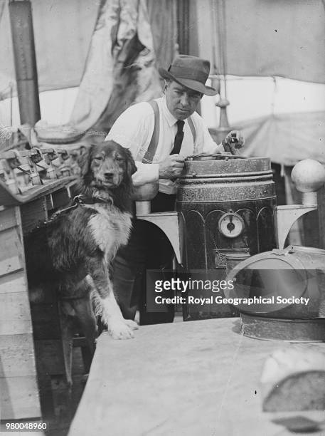 Ernest Shackleton with dog on board ship, Antarctica, 1914. Imperial Trans-Antarctic Expedition 1914-1916 .