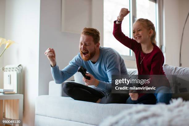 dad and daugther playing video games - family time stock pictures, royalty-free photos & images