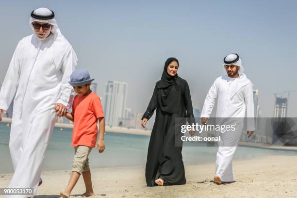 arab family walking on the autumn beach - bahrain man stock pictures, royalty-free photos & images