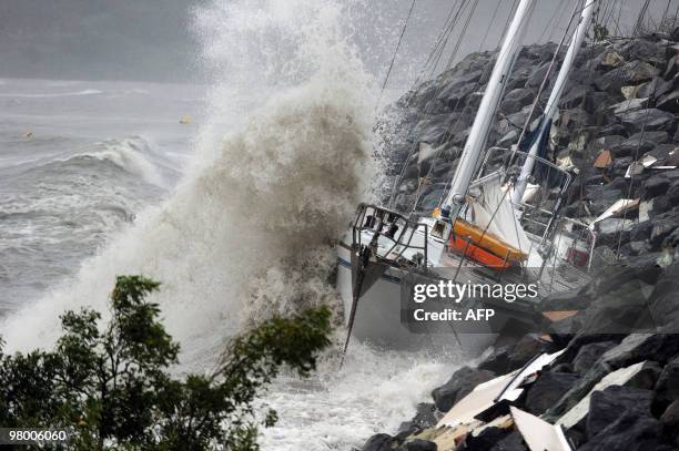 Waves stirred up by Cyclone Ului batter former Sydney to Hobart race yacht 'Anaconda II' against the seawall at Airlie Beach along the Queensland...