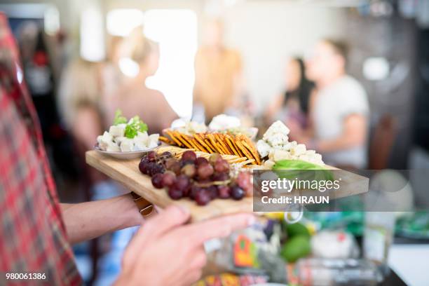 young man holding wooden tray with various food - healthy snacks stock pictures, royalty-free photos & images