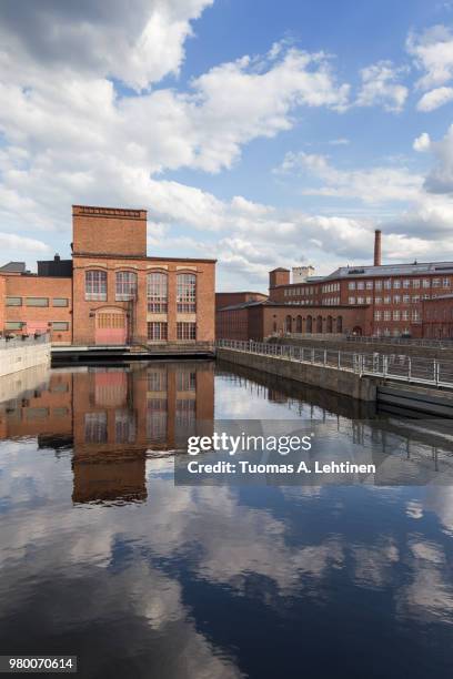 old red brick industrial buildings along the tammerkoski rapids in downtown tampere, finland on a sunny day. - tampere stock pictures, royalty-free photos & images