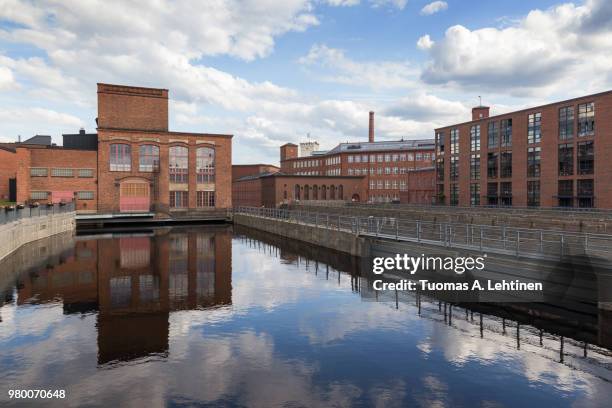 old red brick industrial buildings along the tammerkoski rapids in downtown tampere, finland on a sunny day. - tampere stock pictures, royalty-free photos & images