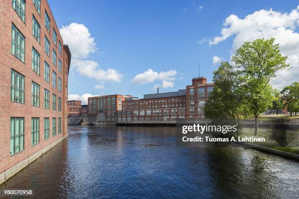 old red brick industrial buildings along the tammerkoski rapids in downtown tampere, finland on a sunny day. - tampere stock pictures, royalty-free photos & images