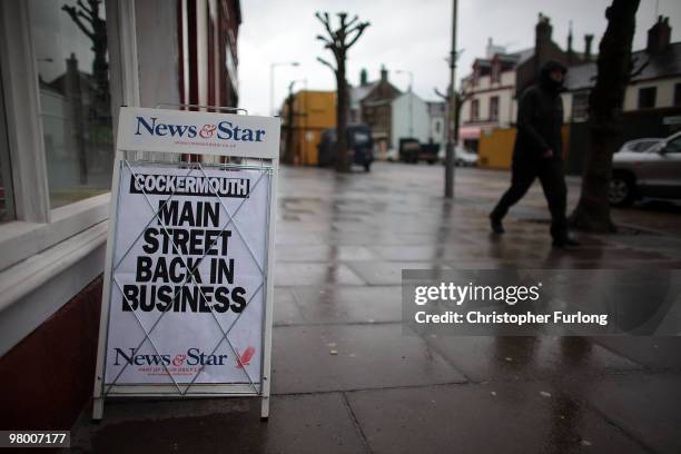 Newspaper A board declares Cockermouth High Street back in business on March 24, 2010 in Cockermouth, England. The Cumbrian town was officially...
