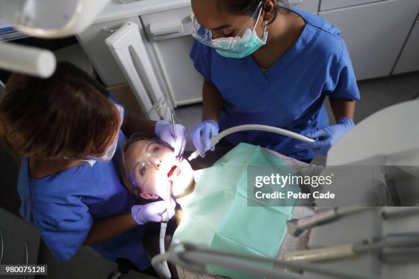 dentist working on patient in chair - root canal procedure stock-fotos und bilder