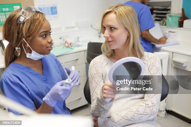dentist talking to patient about electric toothbrush - periodontal disease stock pictures, royalty-free photos & images
