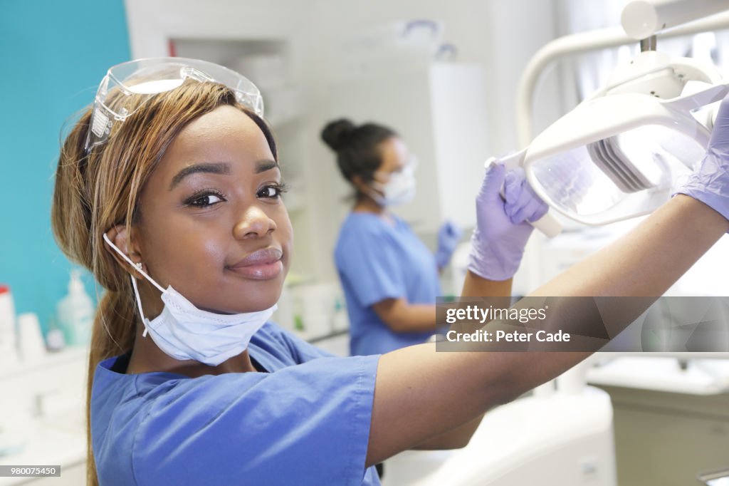 Dentist adjusting light over chair