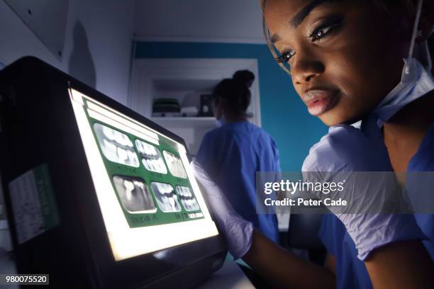 dentist looking at x rays - dental equipment stock pictures, royalty-free photos & images