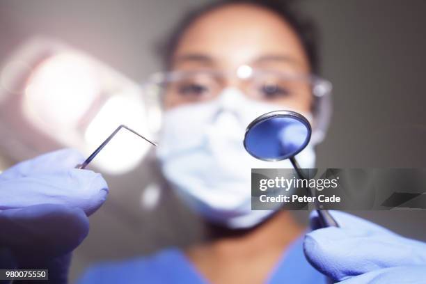 dentist looking down on camera with tools in hand - plaque remover stock pictures, royalty-free photos & images