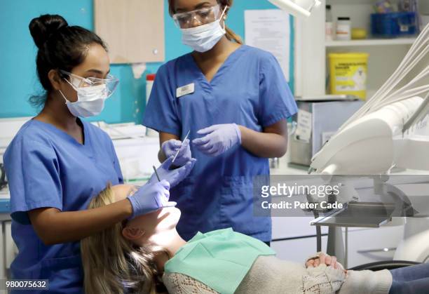 dentist working on patient in chair - dentistry stock pictures, royalty-free photos & images