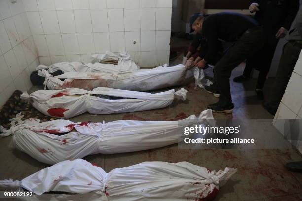 Bodies of Syrian civilian victims in a makeshift hospital prepared for burial after they were killed during during air strikes by forces loyal to...