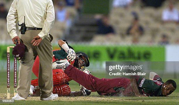 Marlon Samuels collides with Grant Flower of Zimbabwe during the Carlton Series One Day International between West Indies and Zimbabwe at the...