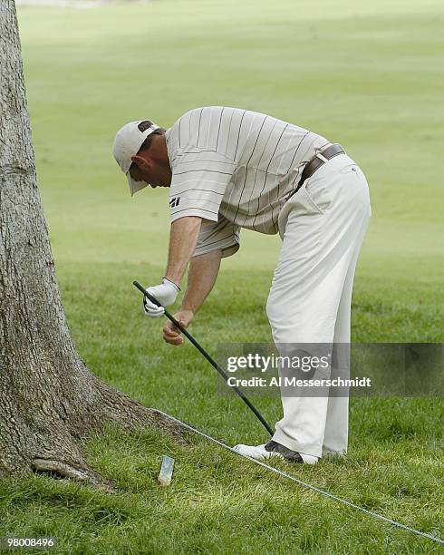 Patrick Sheehan attempts to remove a stake on the 18th hole during third round play July 10, 2004 at the PGA Tour John Deere Classic.