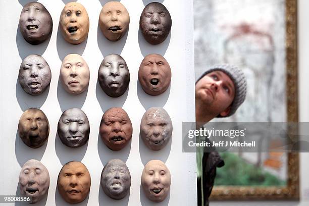 Exhibitor views ceramic heads by Johan Thunell at Glasgow Art Fair on March 24, 2010 in Glasgow, Scotland. Held in George Square in the heart of the...