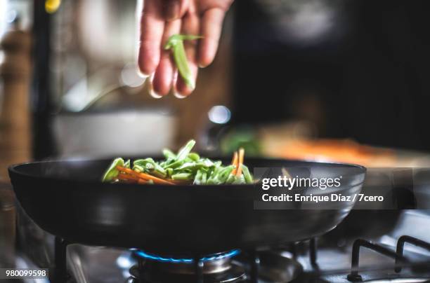 sprinklinging shredded vegetables in a pan for korean pancakes. - kochgeschirr stock-fotos und bilder