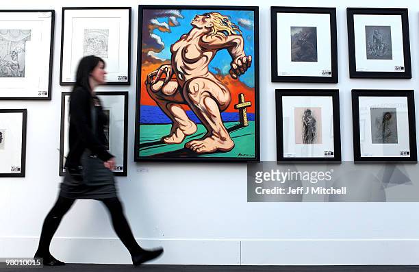 An exhibitor walks past a Peter Howson oil painting of Madonna at Glasgow Art Fair on March 24, 2010 in Glasgow, Scotland. Held in George Square in...