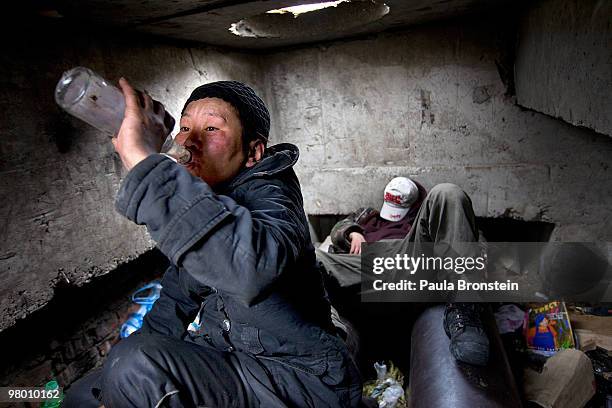 Erdenetsetseg drinks vodka sitting on a water pipe she uses as her bed in the garbage filled sewer that she lives March 13, 2010 in Ulaan Baatar,...
