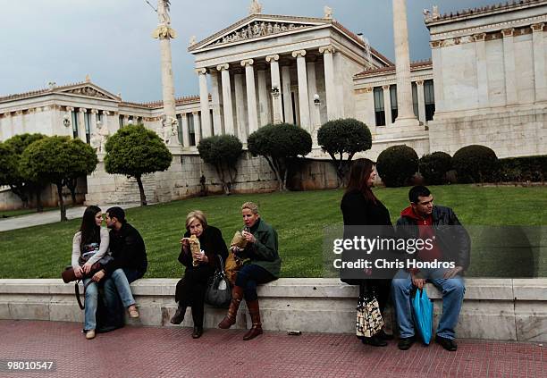 Greeks sit on a low wall in front of the Academy of Athens on March 24, 2010 in Athens, Greece. Fellow European nations negotiated on March 24 over...